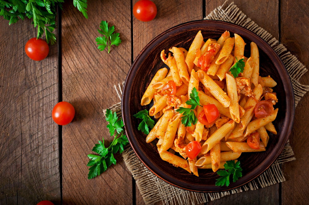 penne pasta tomato sauce with chicken tomatoes wooden table